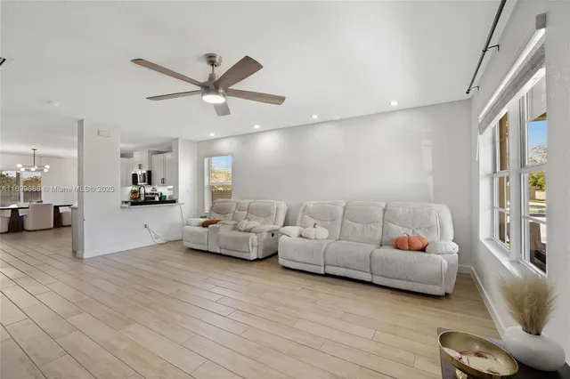 a dining room with furniture potted plants and wooden floor