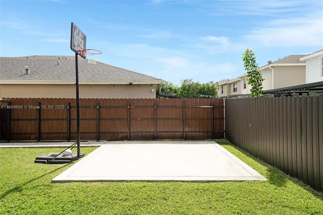 a view of an empty room with wooden floor and windows