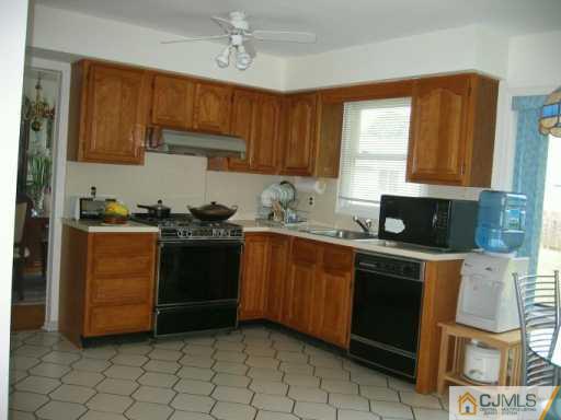 104 Roxy Avenue Edison, NJ 08820 - Photo 3 of 5 a kitchen with stainless steel appliances granite countertop a stove a sink and a microwave