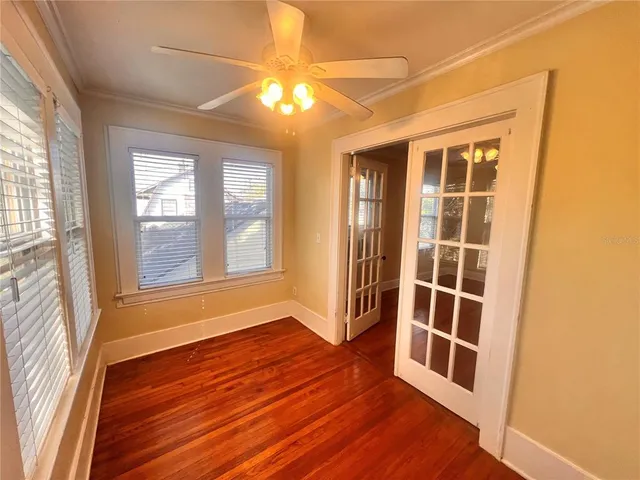 an empty room with wooden floor and windows