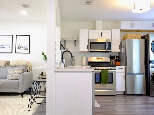a kitchen with a refrigerator a stove a microwave and cabinets
