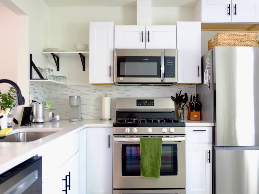 1401 Marcus Place, Unit B Austin, TX 78721 - Photo 14 of 38 a kitchen with cabinets and stainless steel appliances
