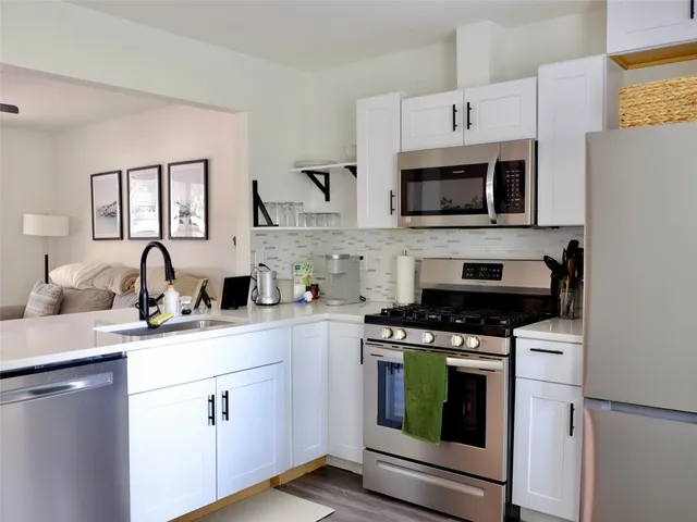 a kitchen with cabinets a sink and stainless steel appliances