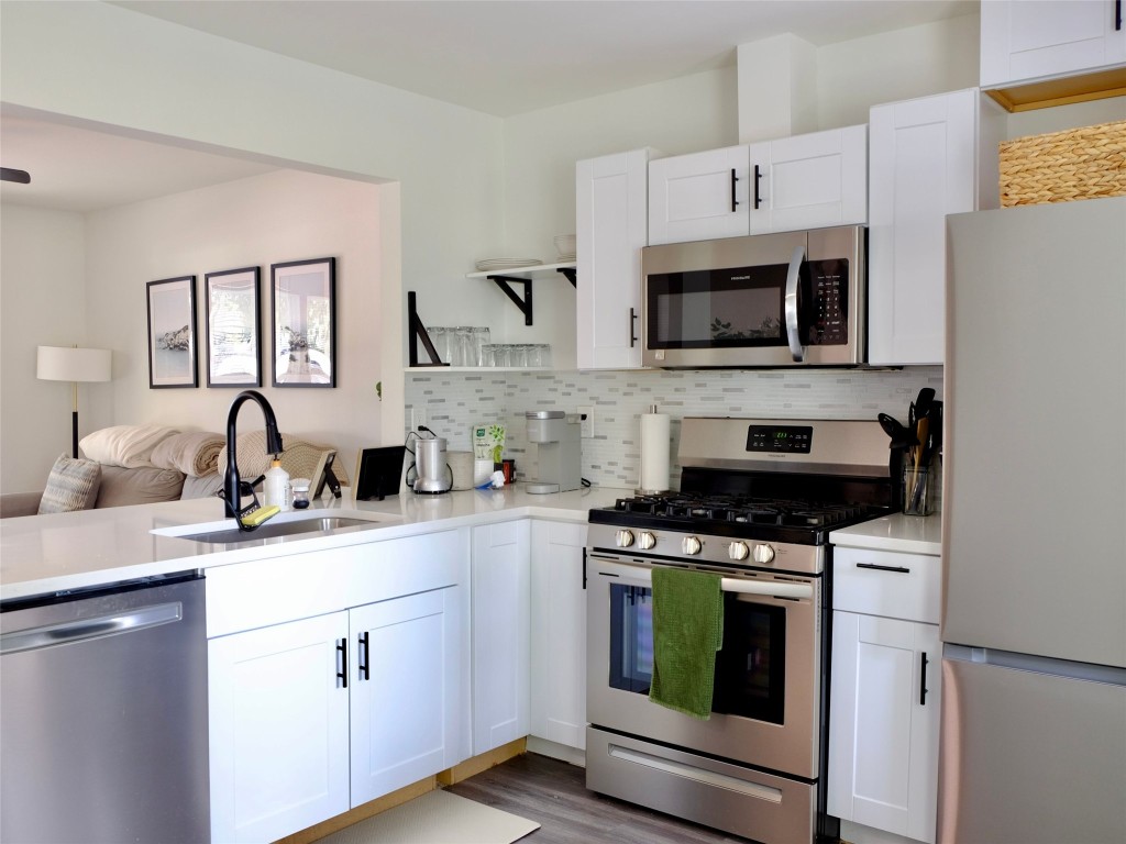 1401 Marcus Place, Unit B Austin, TX 78721 - Photo 15 of 38 a kitchen with cabinets a sink and stainless steel appliances