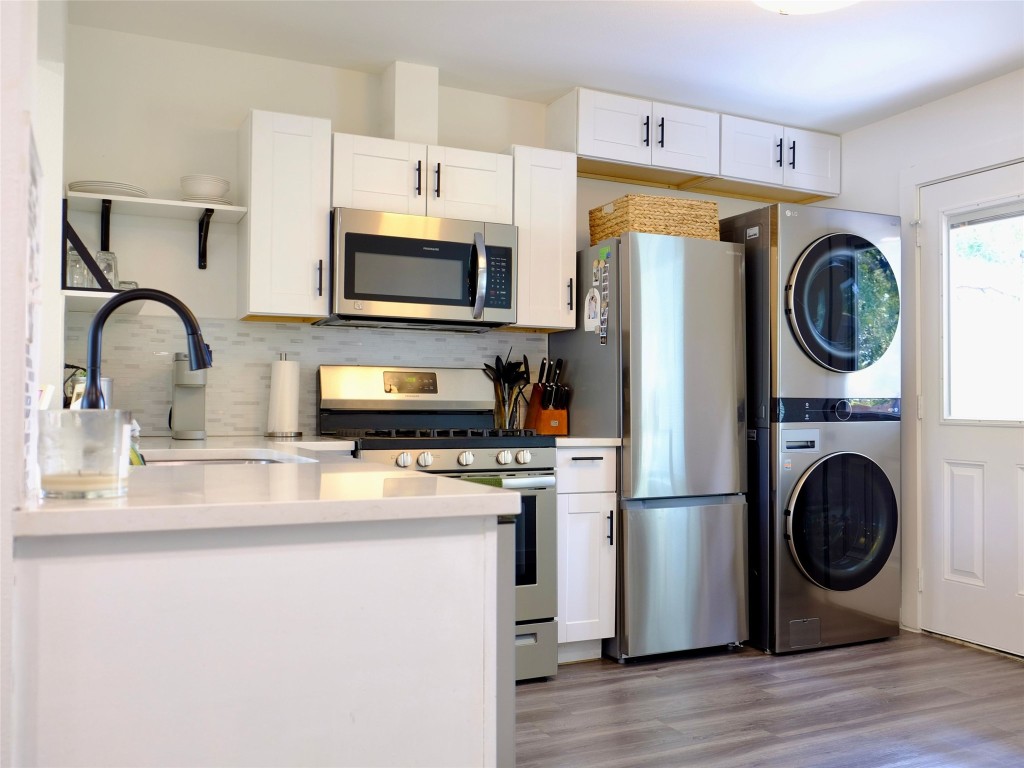 1401 Marcus Place, Unit B Austin, TX 78721 - Photo 16 of 38 a kitchen with stainless steel appliances granite countertop a stove a sink dishwasher and a refrigerator with wooden floor
