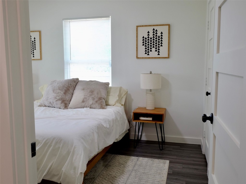 1401 Marcus Place, Unit B Austin, TX 78721 - Photo 26 of 38 a bedroom with a bed and wooden floor