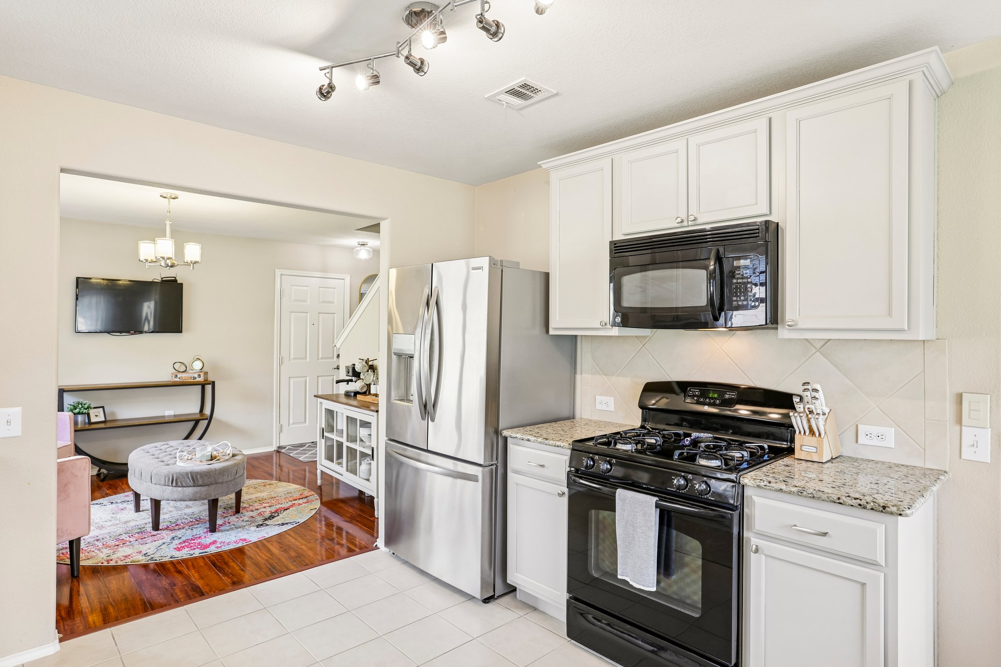 5508 Emma Thompson Way Austin, TX 78747 - Photo 14 of 34 The modern kitchen features stainless and black appliances, creating a functional and welcoming space for preparing meals and gathering with loved ones.