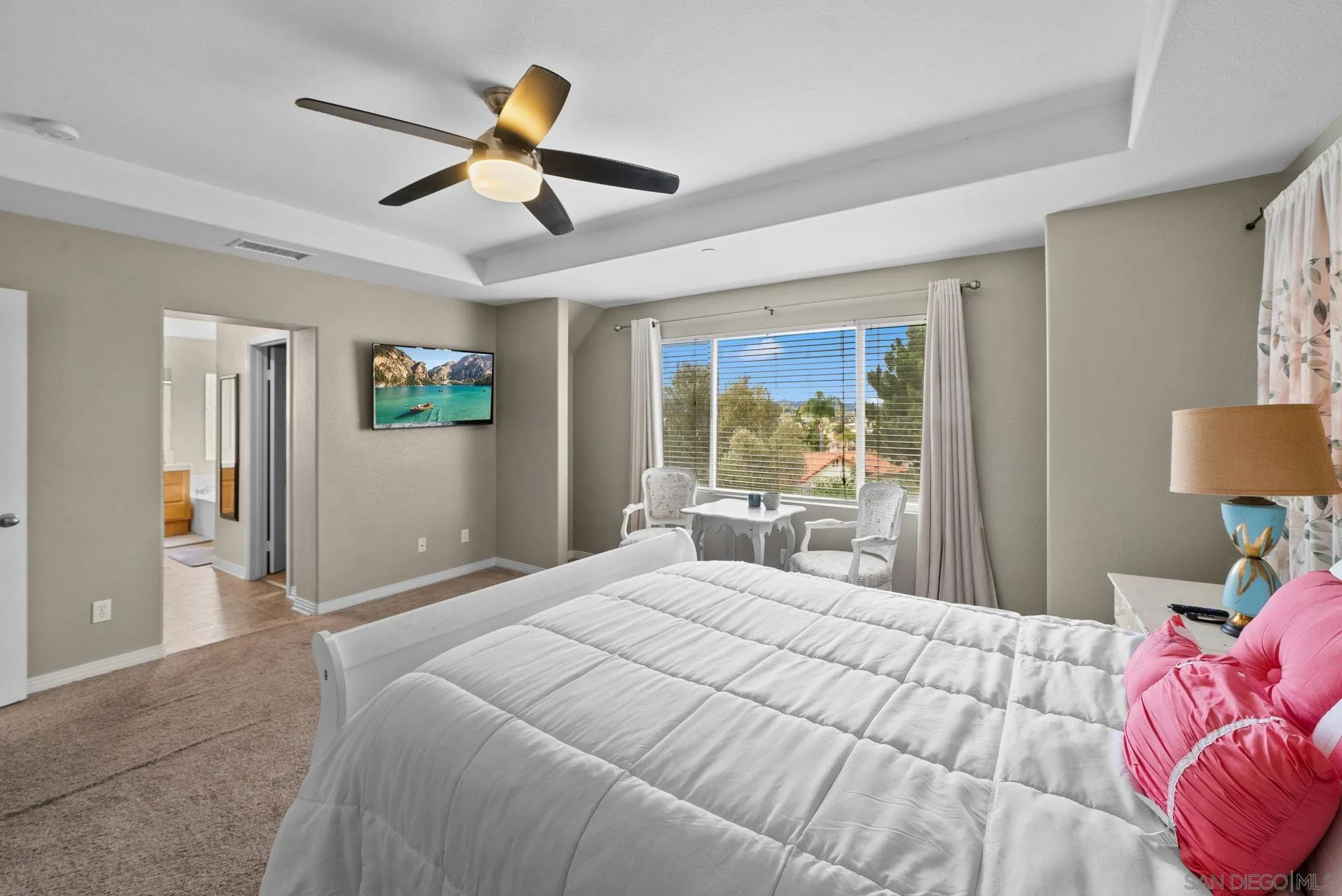 461 Poets Square Fallbrook, CA 92028 - Photo 20 of 40 a bedroom with a large bed and a chandelier fan
