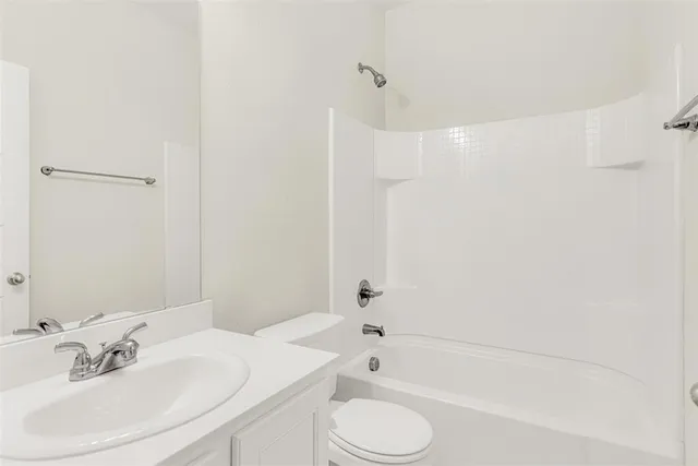 a bathroom with a bathtub shower sink and a toilet