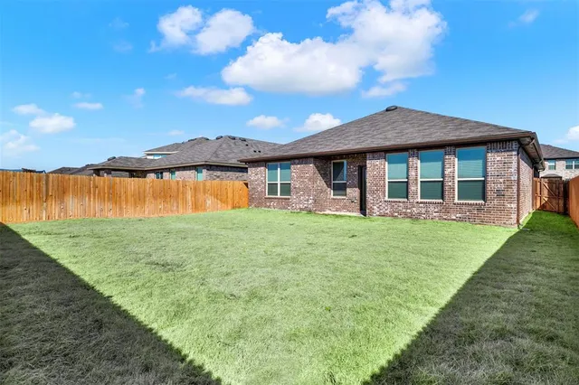 a view of a house with a yard and potted plants