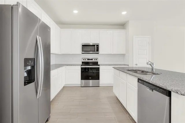 a kitchen with stainless steel appliances granite countertop a refrigerator and a stove