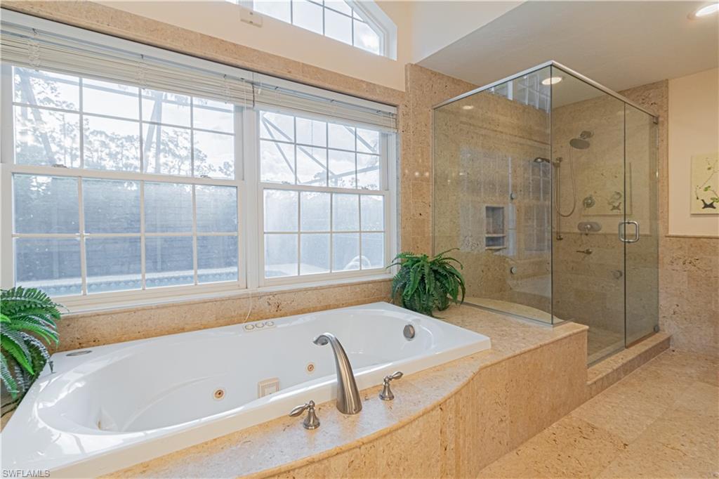 519 Cormorant Cove Naples, FL 34113 - Photo 13 of 32 a bathroom with a tub and shower
