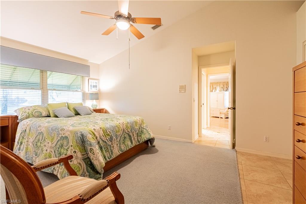 519 Cormorant Cove Naples, FL 34113 - Photo 14 of 32 a spacious bedroom with a bed and a chandelier