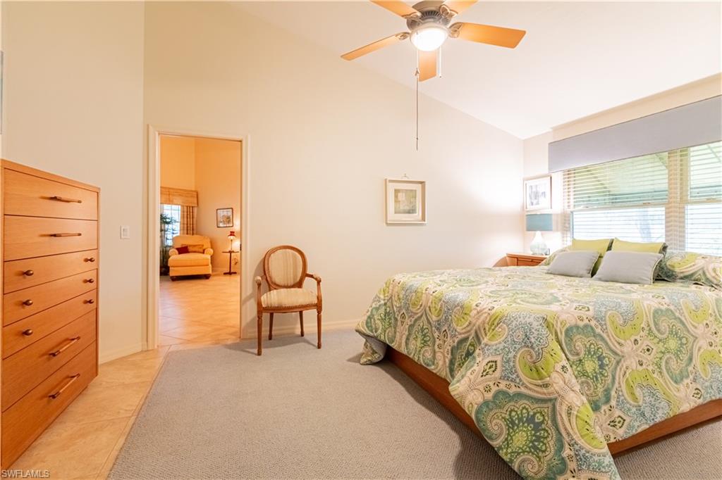 519 Cormorant Cove Naples, FL 34113 - Photo 15 of 32 a bedroom with a bed and a chandelier