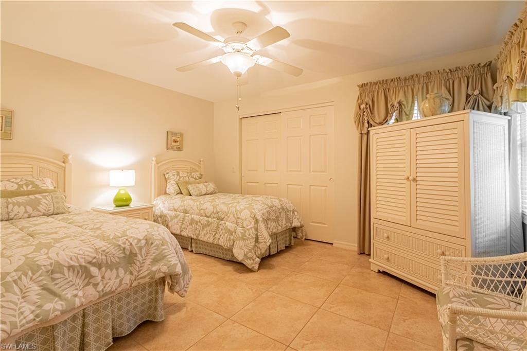 519 Cormorant Cove Naples, FL 34113 - Photo 18 of 32 a bedroom with two beds and a chandelier
