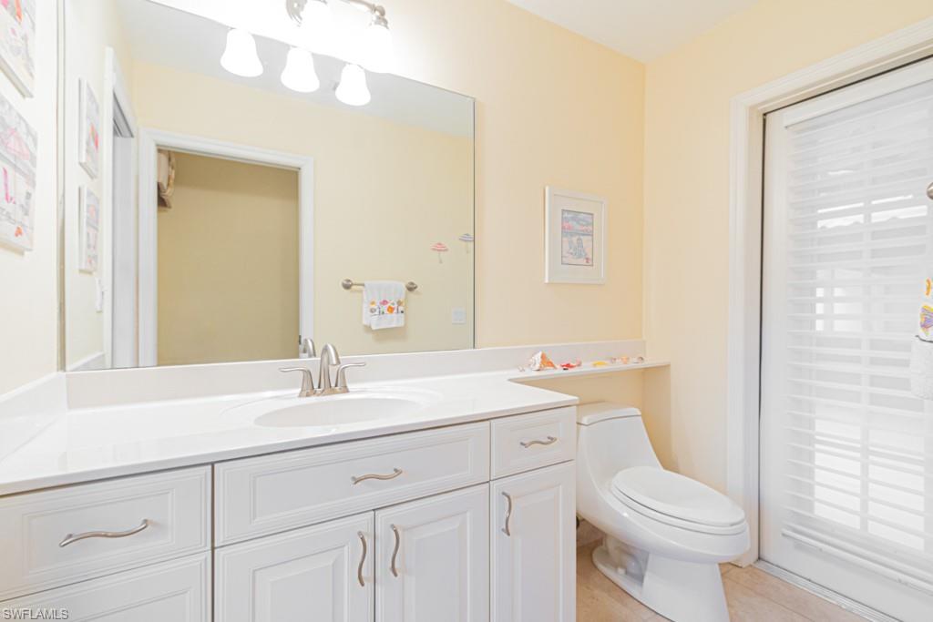 519 Cormorant Cove Naples, FL 34113 - Photo 20 of 32 a bathroom with a sink a toilet a mirror and vanity