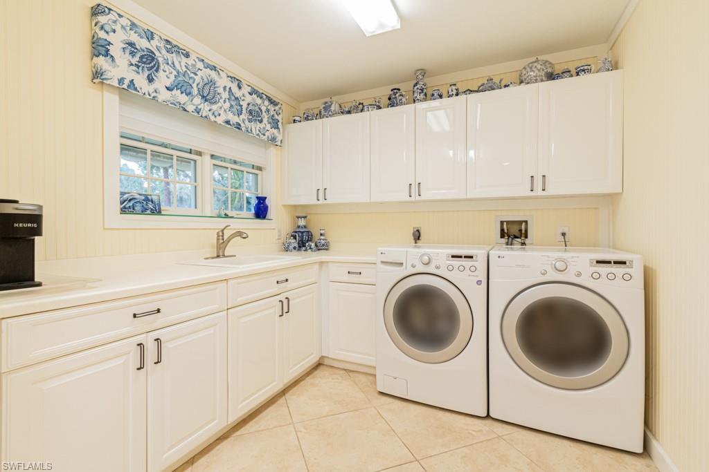 519 Cormorant Cove Naples, FL 34113 - Photo 22 of 32 a kitchen with a sink a washer and dryer next to a window