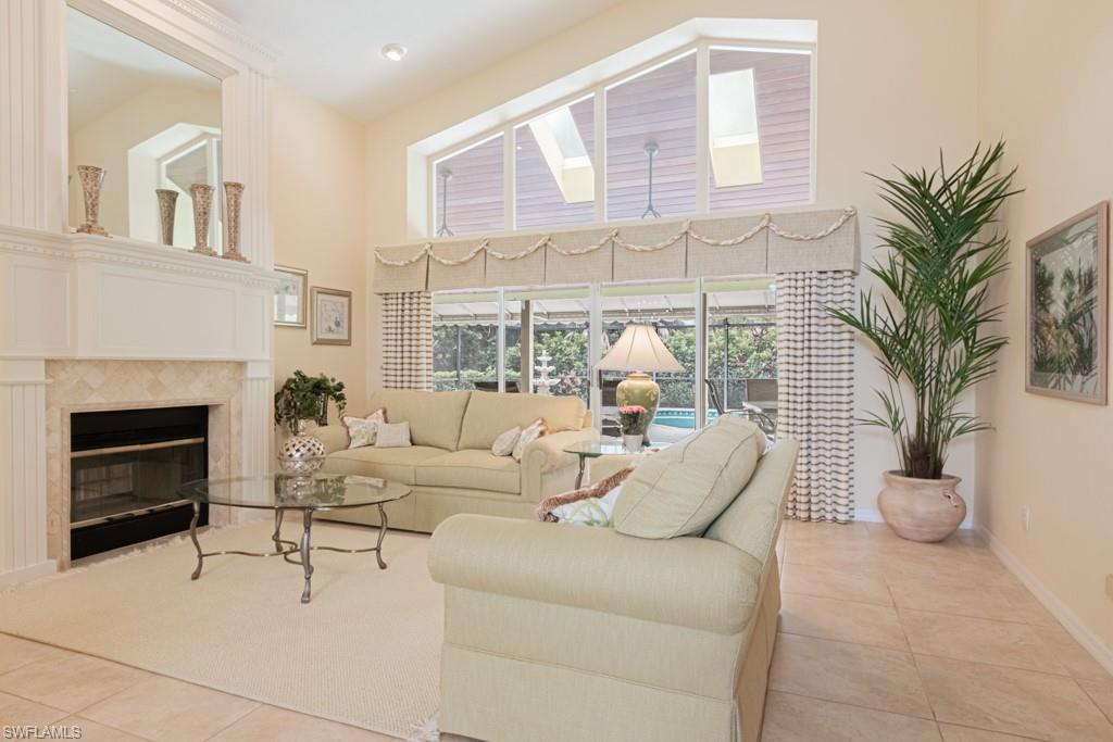 519 Cormorant Cove Naples, FL 34113 - Photo 4 of 32 a living room with furniture a fireplace and a potted plant