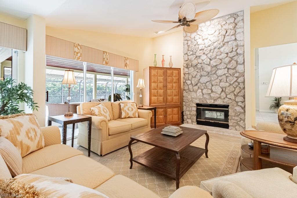 519 Cormorant Cove Naples, FL 34113 - Photo 5 of 32 a living room with furniture large window and fireplace