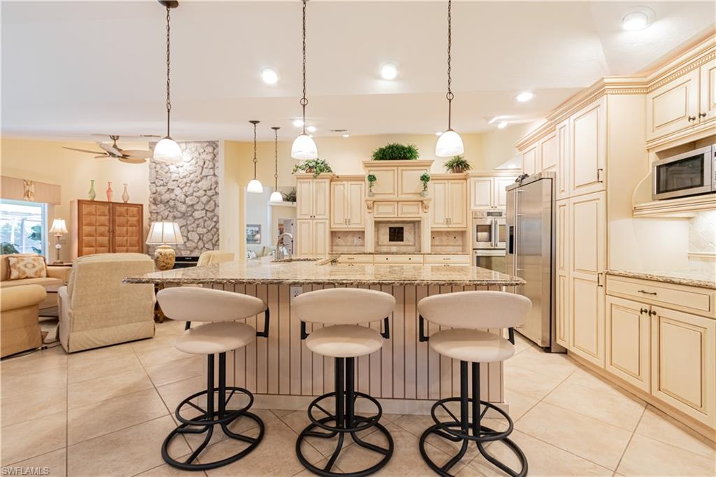 519 Cormorant Cove Naples, FL 34113 - Photo 9 of 32 a large kitchen with a table and chairs