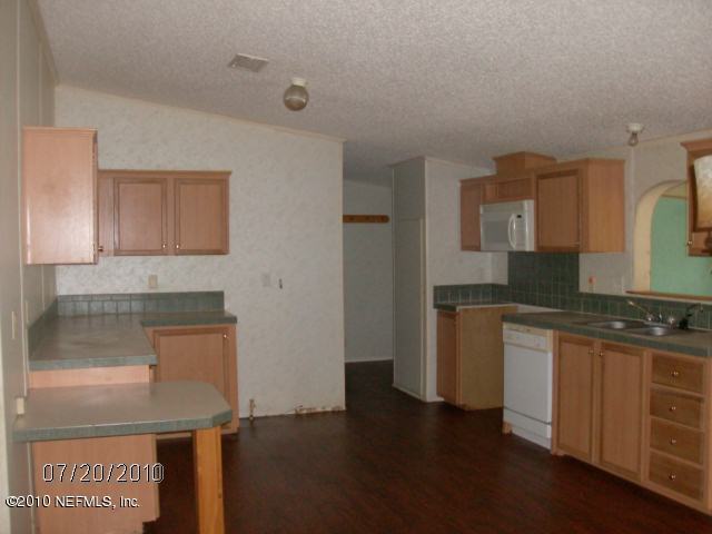 4129 Pinto Road Middleburg, FL 32068 - Photo 4 of 10 a kitchen with granite countertop a sink and a stove top oven