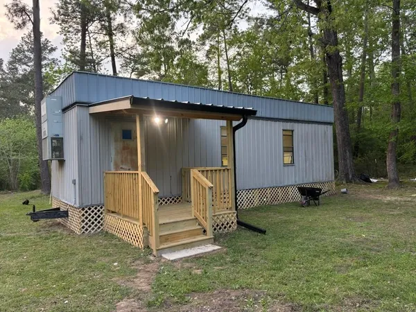a view of a house with backyard and a tree