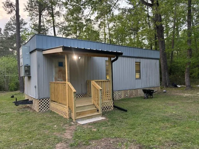 a view of a house with backyard and a tree