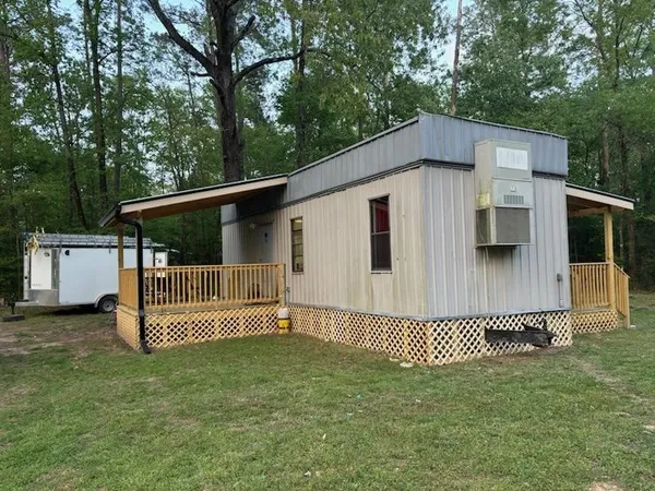a white house that has tree in front of it