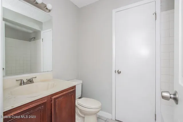 a bathroom with a granite countertop sink toilet and a mirror