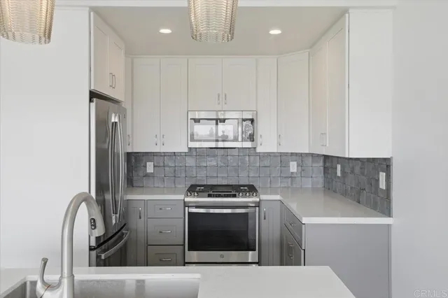 a kitchen with granite countertop white cabinets and stainless steel appliances