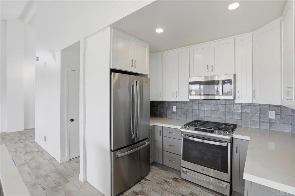 6686 Corte Maria Carlsbad, CA 92009 - Photo 12 of 28 a kitchen with stainless steel appliances a refrigerator stove and white cabinets