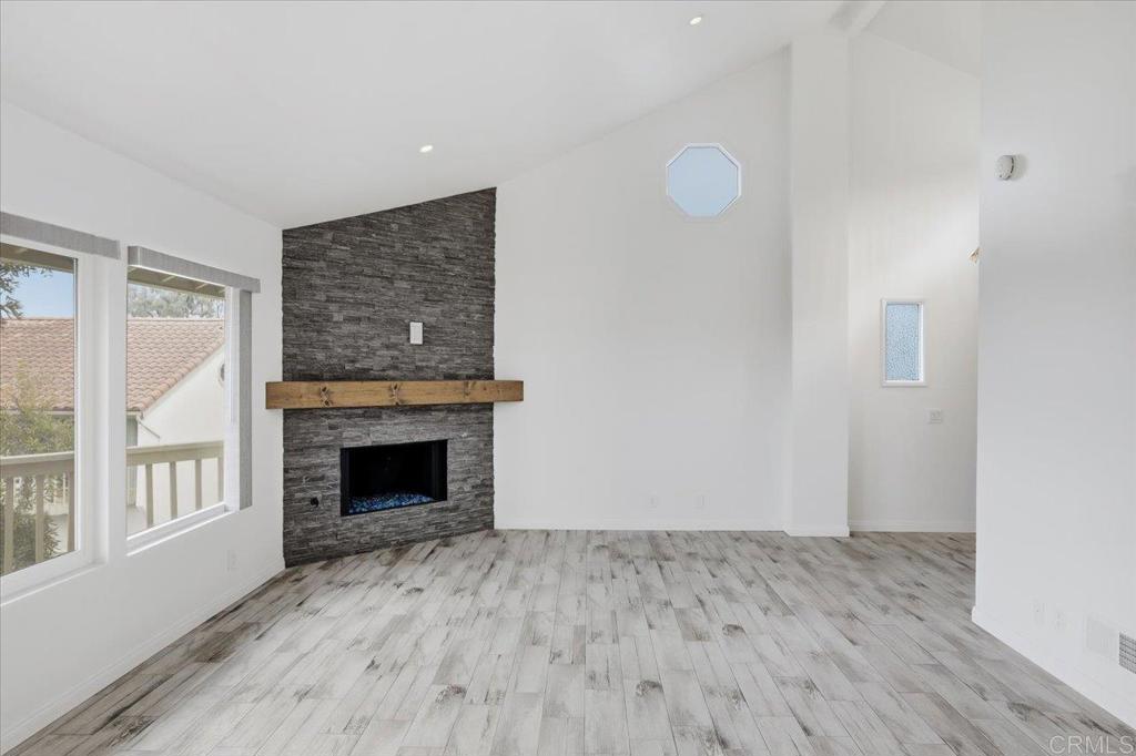 6686 Corte Maria Carlsbad, CA 92009 - Photo 7 of 28 a view of an empty room with wooden floor fireplace and a window