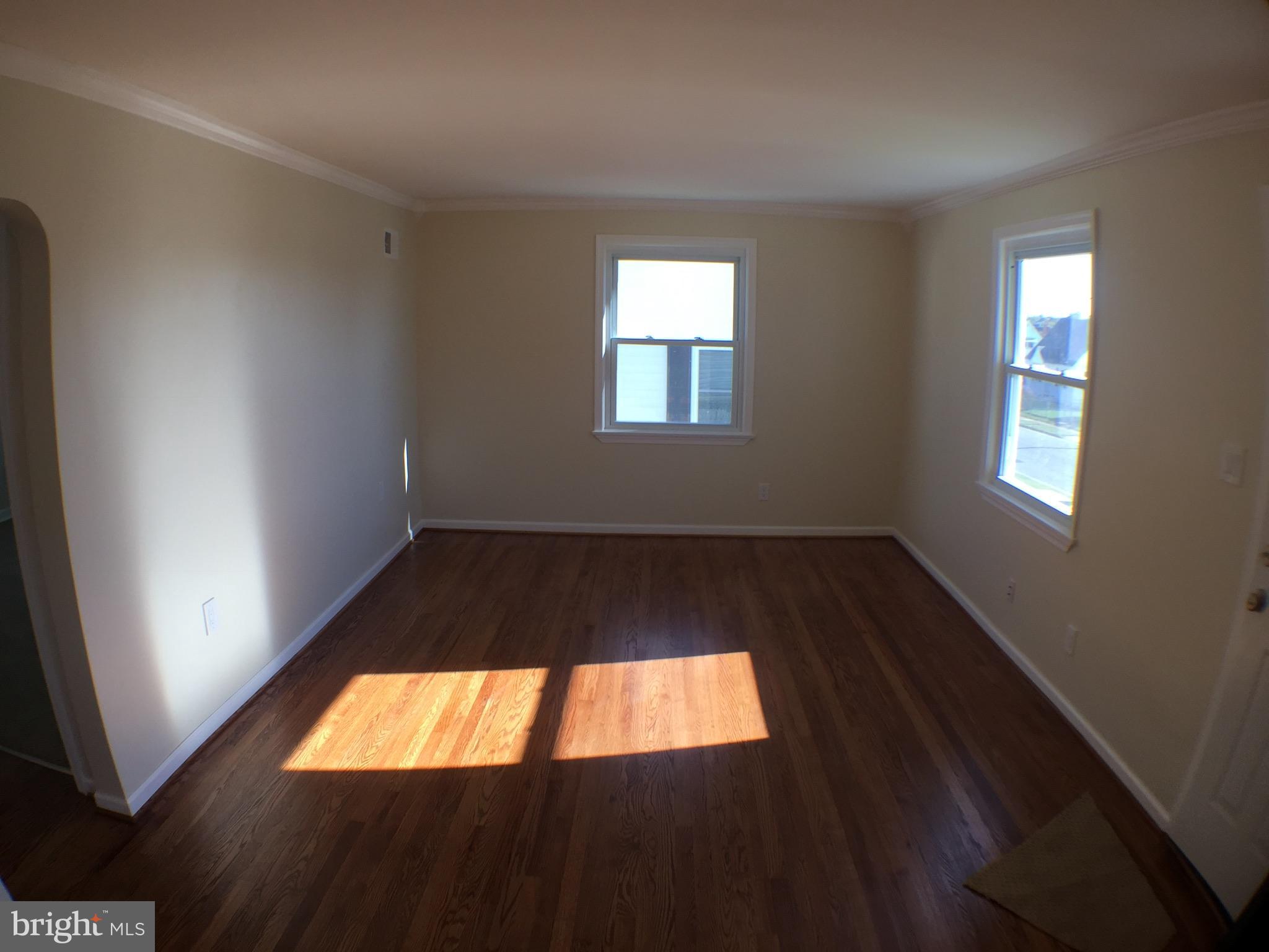 1517 Rita Road Baltimore, MD 21222 - Photo 8 of 12 an empty room with wooden floor and windows