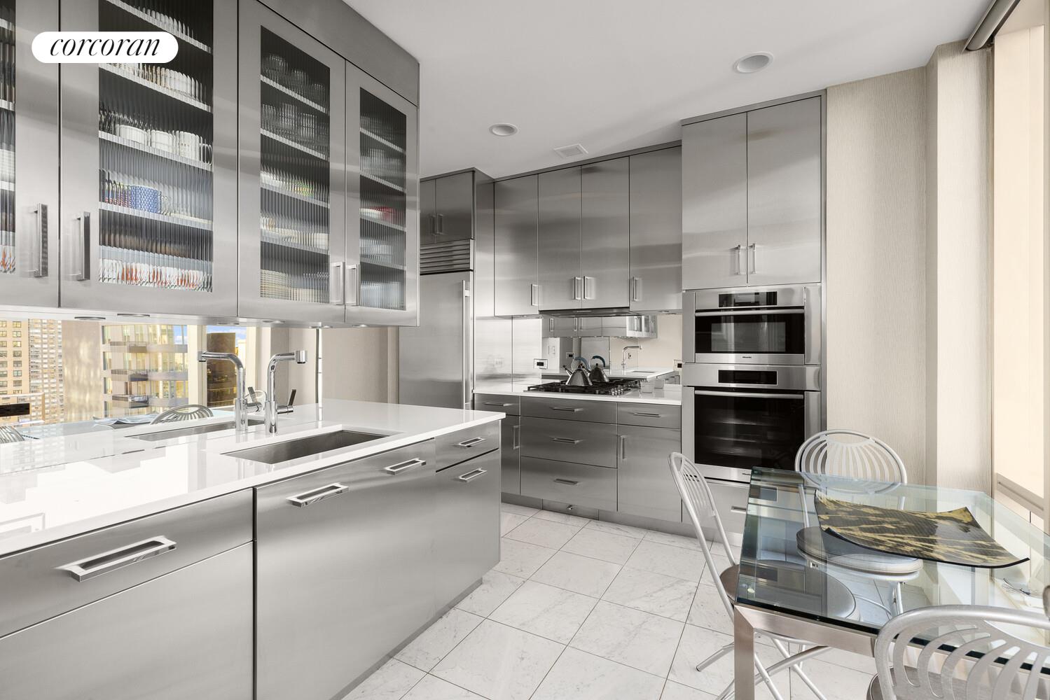 1 Central Park West, Unit 30G Manhattan, NY 10023 - Photo 4 of 10 a kitchen with stainless steel appliances kitchen island granite countertop a sink stove and cabinets