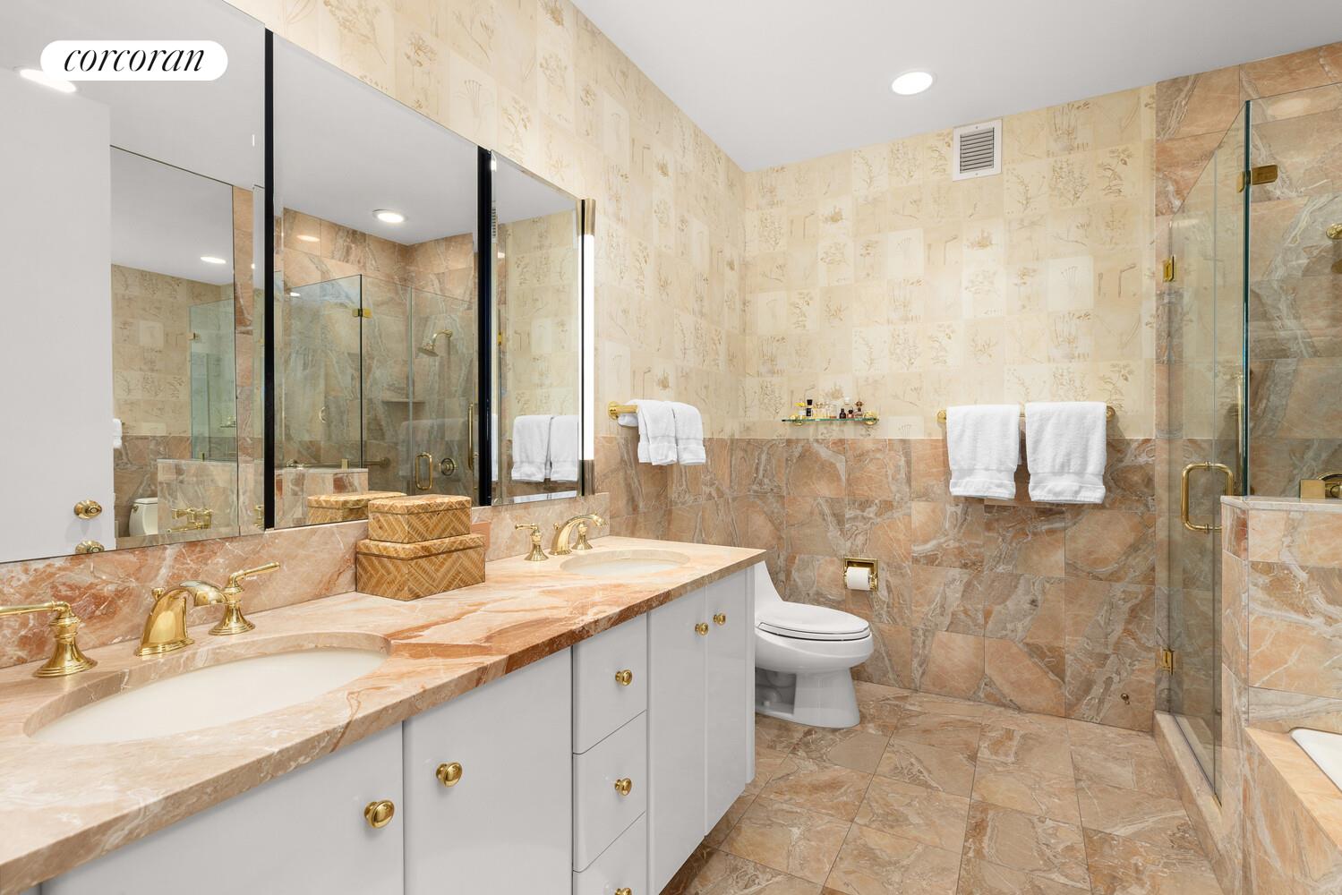 1 Central Park West, Unit 30G Manhattan, NY 10023 - Photo 6 of 10 a bathroom with a double vanity sink toilet and a mirror