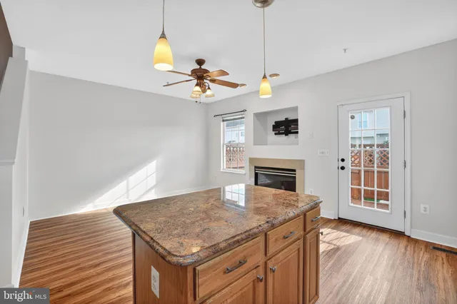 a living room with a kitchen island furniture a fireplace and a window