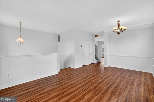 a view of empty room with wooden floor and ceiling fan