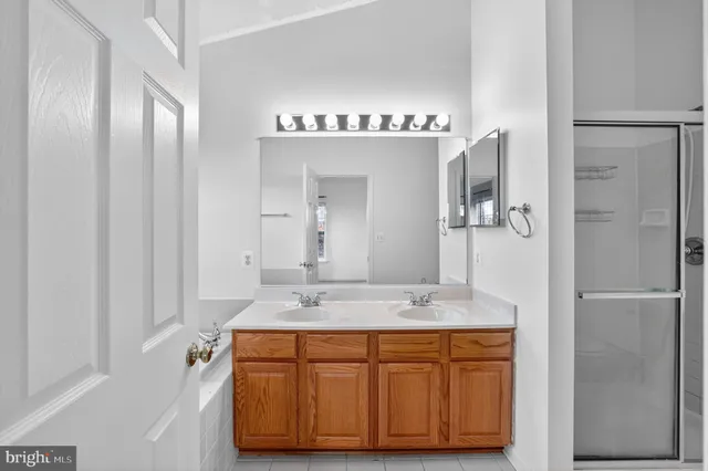 a view of a livingroom with a fireplace a ceiling fan and wooden floor