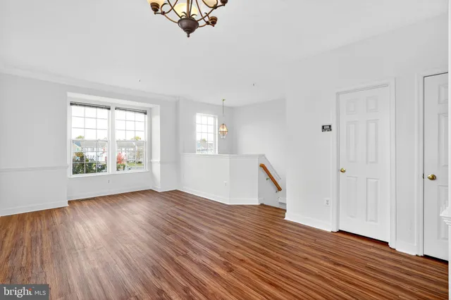 an empty room with windows and ceiling fan