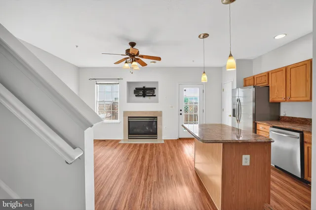 a kitchen with stainless steel appliances granite countertop a sink and a refrigerator
