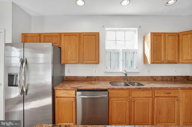 a bathroom with a granite countertop sink a toilet and a mirror