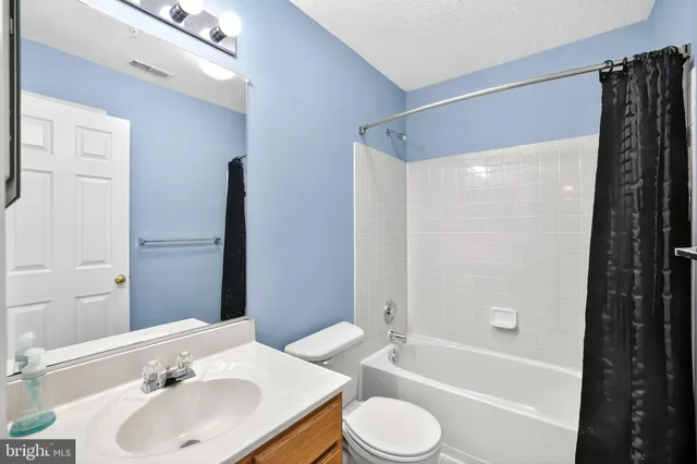 a bathroom with a tub a double vanity sink and mirror