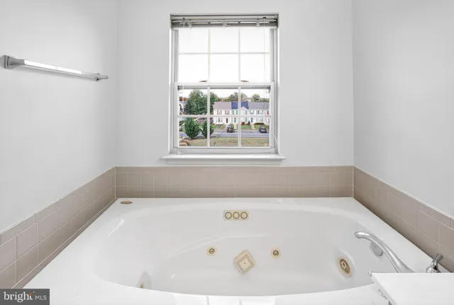 a white bath tub sitting in a bathroom next to a window