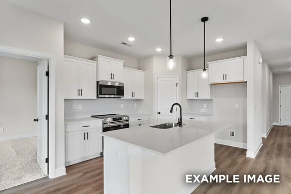 a kitchen with cabinets stainless steel appliances and wooden floor