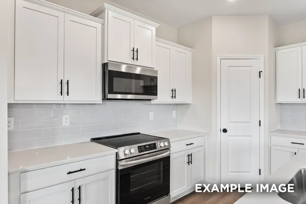 a kitchen with stainless steel appliances granite countertop a sink a stove and a wooden floor