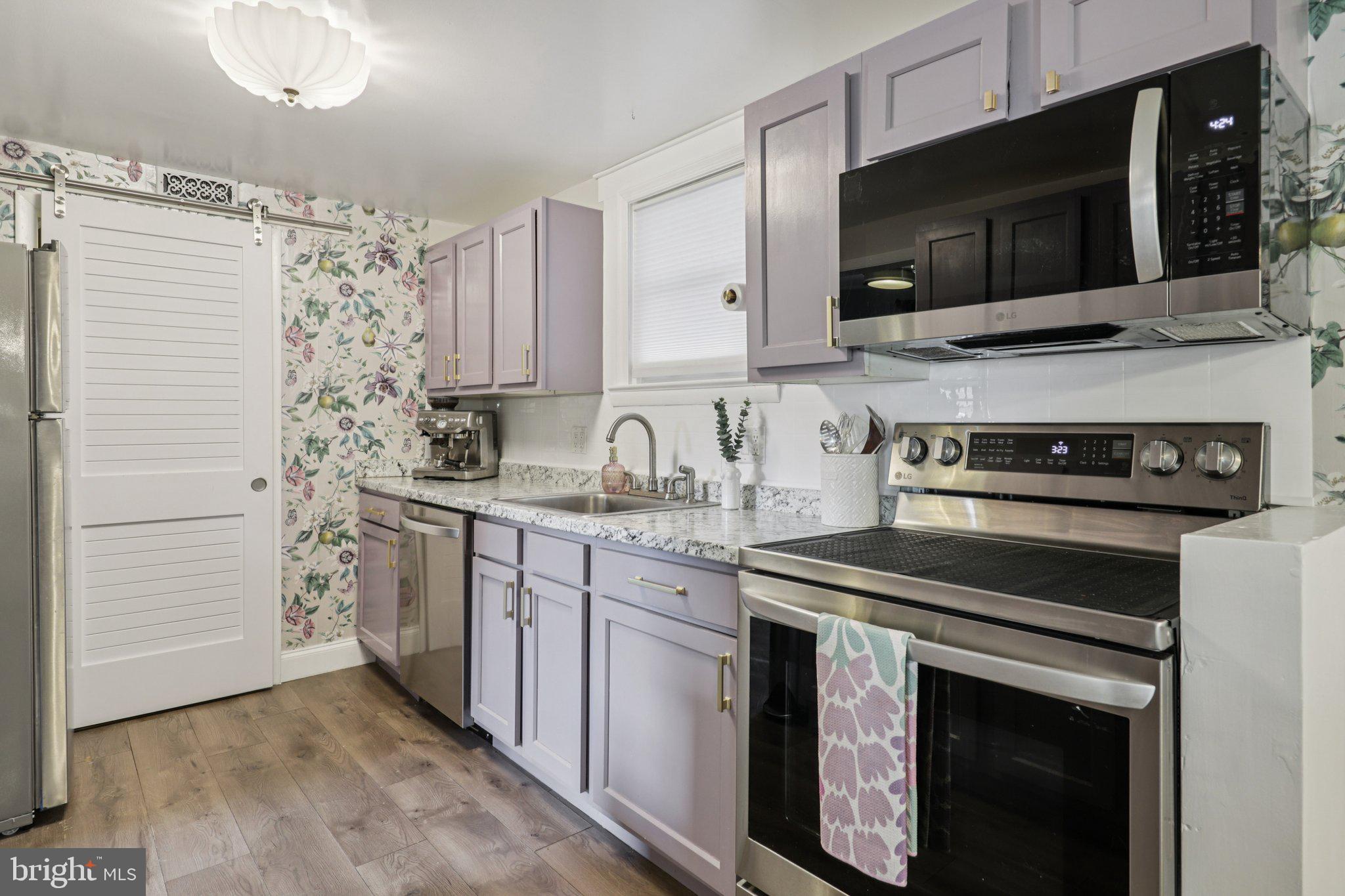 6501 Sligo Parkway Hyattsville, MD 20782 - Photo 7 of 25 a kitchen with stainless steel appliances a stove a microwave sink and cabinets