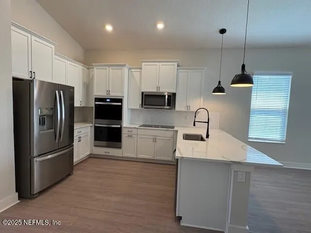 a kitchen with kitchen island a counter top space stainless steel appliances and cabinets