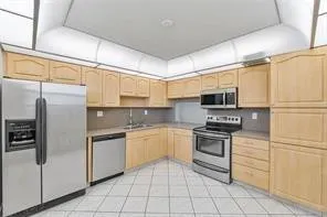 a kitchen with stainless steel appliances granite countertop a refrigerator and a stove top oven