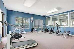 a room with gym equipment and large mirror