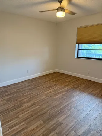 a view of an empty room with wooden floor